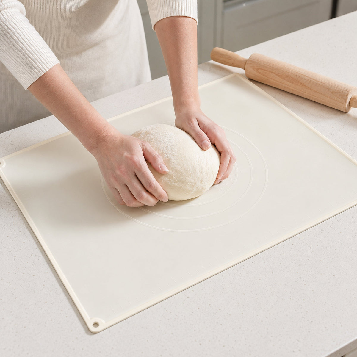 Silicone pastry mat shown in use for kneading dough
